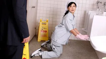 Một người phụ nữ dọn dẹp gọn gàng than van trong nhà vệ sinh.