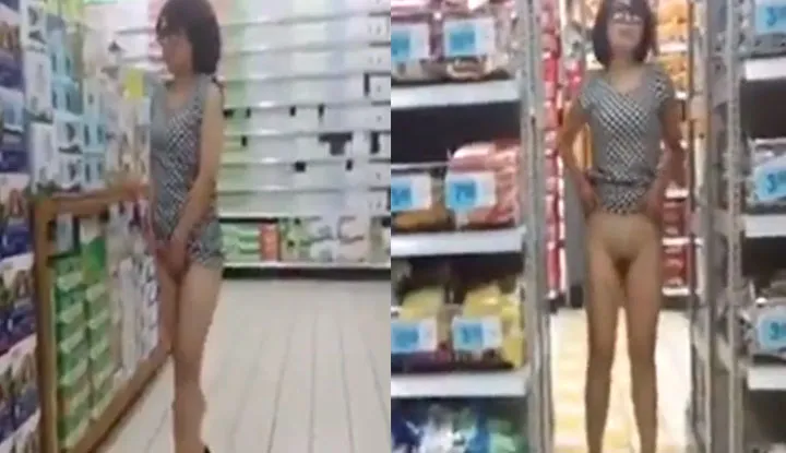 A young woman shopping at a large store...bends over and reveals a noticeable