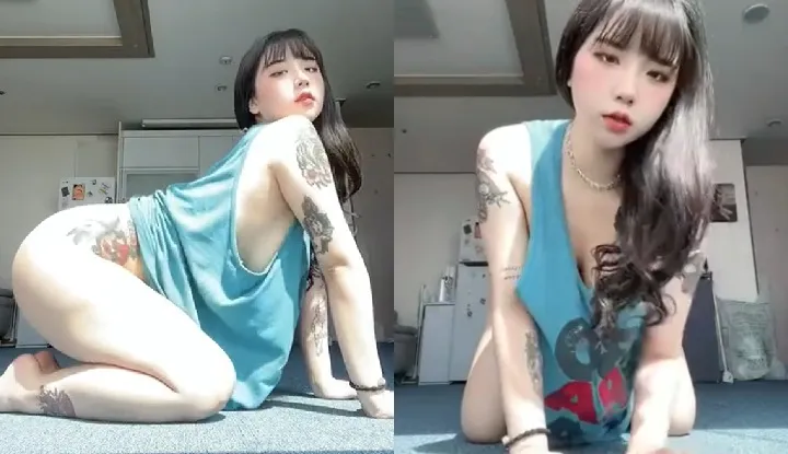 Une fille tatouée et provocante se prenant en selfie pour séduire, ses seins d'une blancheur éclatante et voluptueux, presque dévoilés, captivent irrésistiblement le regard.